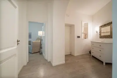 a white hallway with a dresser and a bedroom at Rome Sweet Home near Metro Flaminio in Rome