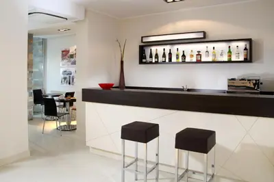 a bar with black stools and bottles on the wall at Residence Hotel Parioli in Rome