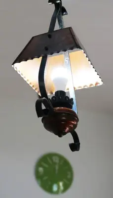 a light hanging from a ceiling with a green clock at Il Giardino Al Pigneto in Rome