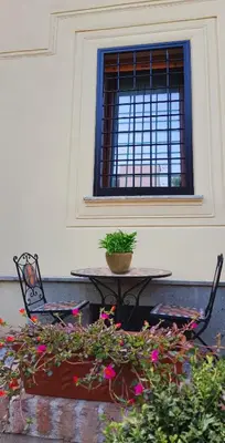 a table and chairs with flowers in front of a window at Il Giardino Al Pigneto in Rome