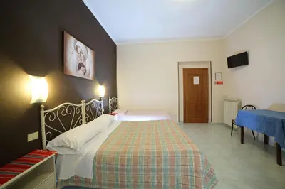 a bedroom with a large bed with a plaid blanket at Hotel Giugiù in Rome