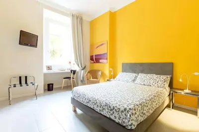 a bedroom with a bed and a yellow wall at Paola Guest House in Rome