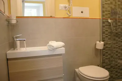 a bathroom with a toilet and a sink and a shower at Paola Guest House in Rome