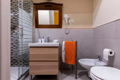 a bathroom with a sink and a toilet and a mirror at Paola Guest House in Rome