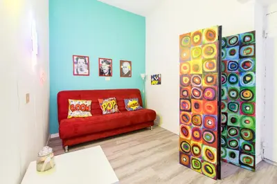 a living room with a red couch and colorful walls at Pop House in Rome