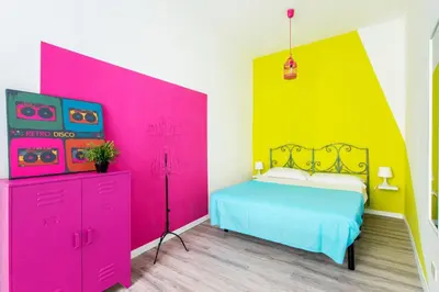 a bedroom with a pink and yellow wall at Pop House in Rome