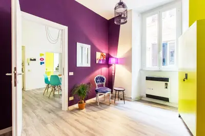 a living room with purple walls and chairs at Pop House in Rome