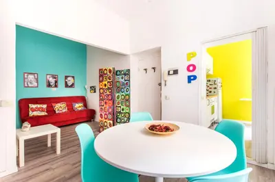 a dining room with a white table and blue chairs at Pop House in Rome