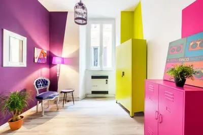a room with colorful walls and a chair and a cabinet at Pop House in Rome