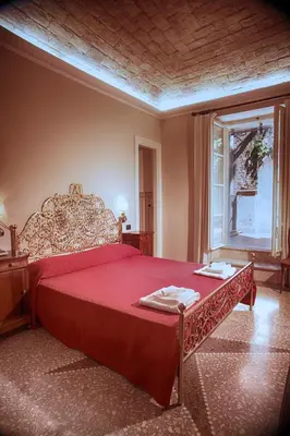 a bedroom with a large red bed and a window at Domus Real Cardello in Rome