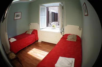 two beds in a room with a window at Domus Real Cardello in Rome