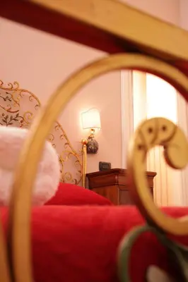 a bedroom with a red bed and a mirror at Domus Real Cardello in Rome