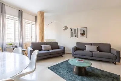 a living room with two couches and a glass table at ROMAC San Saba 5-Bedroom and Terrace near Ostiense in Rome