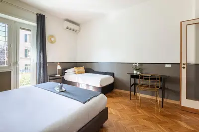 a hotel room with two beds and a window at ROMAC San Saba 5-Bedroom and Terrace near Ostiense in Rome