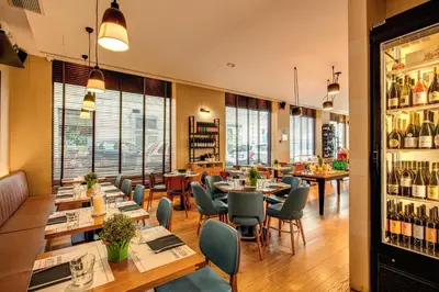 a restaurant with tables and chairs and wine bottles at Prassede Palace Hotel in Rome