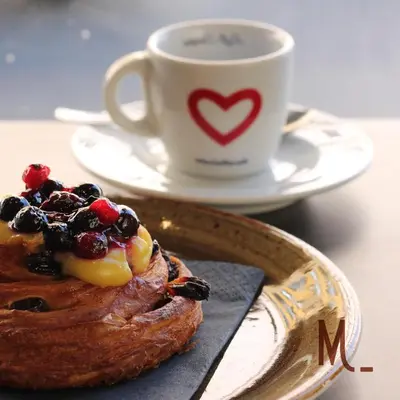 a plate with a pastry and a cup of coffee at Prassede Palace Hotel in Rome