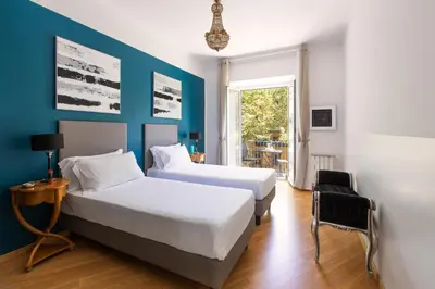 a bedroom with two beds and a blue wall at ROMAC Gianicolo 3-Bedroom Holiday Apartment in Rome