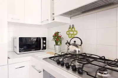 a kitchen with a stove with a tea kettle on it at ROMAC Gianicolo 3-Bedroom Holiday Apartment in Rome