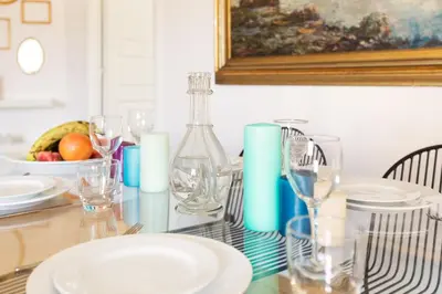 a dining room table with plates and glasses on it at ROMAC Gianicolo 3-Bedroom Holiday Apartment in Rome