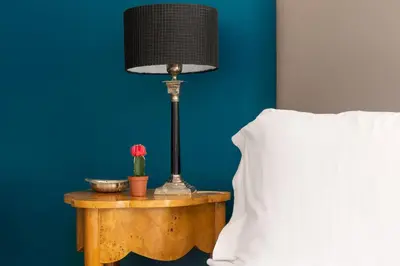 a lamp on a table next to a bed at ROMAC Gianicolo 3-Bedroom Holiday Apartment in Rome