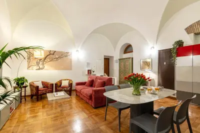a living room with a red couch and a table at ROMAC Coronari with gym, sauna and garden in Rome