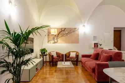 a living room with a red couch and two chairs at ROMAC Coronari with gym, sauna and garden in Rome