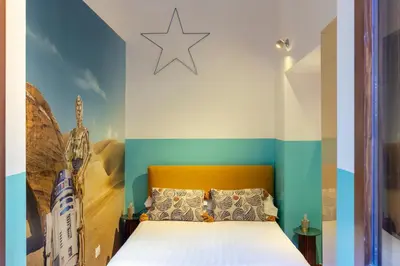 a bedroom with a bed with a star on the wall at ROMAC Coronari with gym, sauna and garden in Rome