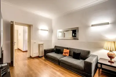 a living room with a couch and a table at Holiday Apartment Bernini Near The Trevi Fountain - 4 Bedroom in Rome