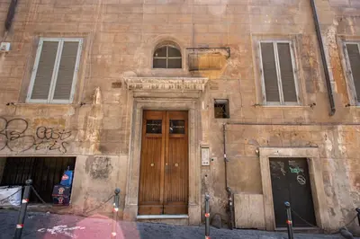 an old building with a wooden door and two windows at Holiday Apartment Bernini Near The Trevi Fountain - 4 Bedroom in Rome