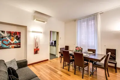 a living room with a dining room table and a couch at Holiday Apartment Bernini Near The Trevi Fountain - 4 Bedroom in Rome