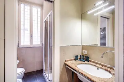 a bathroom with a sink and a toilet at Holiday Apartment Bernini Near The Trevi Fountain - 4 Bedroom in Rome