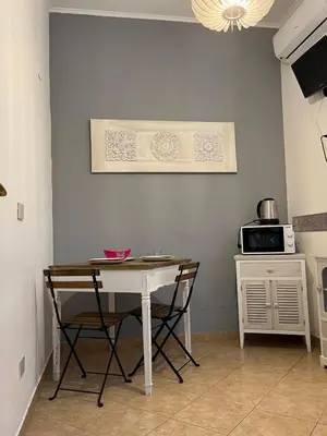 a table and chairs in a kitchen with a microwave at Old Bakery Rome Suites & Apartments in Rome