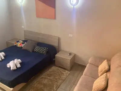 a bedroom with a blue bed and a couch at Old Bakery Rome Suites & Apartments in Rome