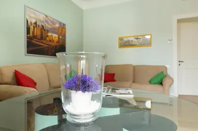 a vase with purple flowers sitting on a glass table at Beautiful apartment in San Giovanni close to Colosseo in Rome