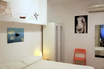 a bedroom with a bed and a red chair at La Casa del Fotografo in Rome