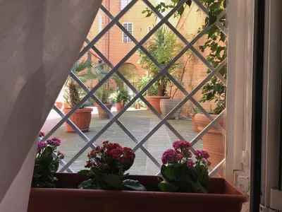 an open window with potted plants on a window sill at La Casa del Fotografo in Rome