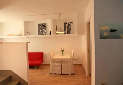 a dining room with a table and a red couch at La Casa del Fotografo in Rome