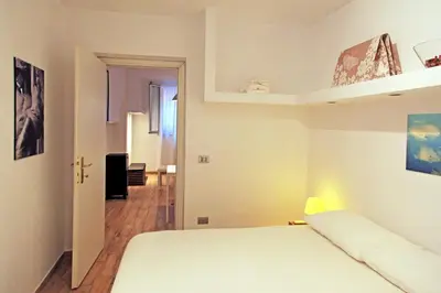 a bedroom with a white bed and a hallway at La Casa del Fotografo in Rome