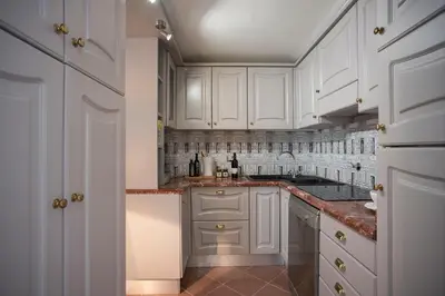 a white kitchen with white cabinets and marble counter tops at Roma Fontana di Trevi in Rome