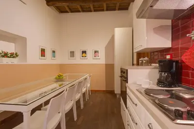 a kitchen with white counter tops and red tiles at ROMAC Baullari Holiday Apartment in Campo de Fiori in Rome