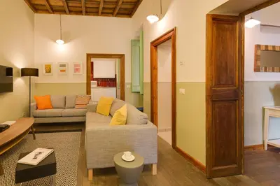 a living room with a couch and a table at ROMAC Baullari Holiday Apartment in Campo de Fiori in Rome