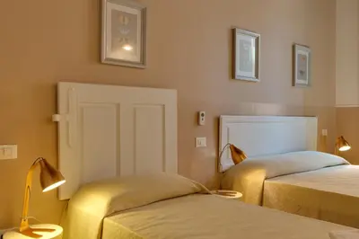a hotel room with two beds and a door at ROMAC Baullari Holiday Apartment in Campo de Fiori in Rome