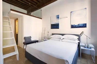 a bedroom with a bed and a ladder and a chair at Experience Collection by ROMAC - Margana Palace in Rome