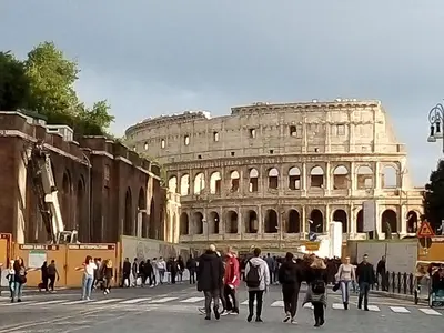 a group of people walking in front of the coliseum at Apartment Rome & More in Rome