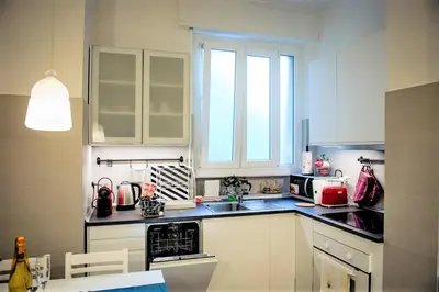 a kitchen with white cabinets and a sink at Sonny Capone Al Vaticano in Rome