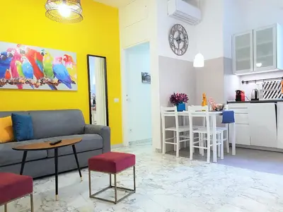 a living room with a couch and a table and a kitchen at Sonny Capone Al Vaticano in Rome