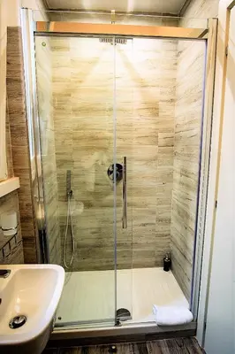 a shower with a glass door next to a sink at Sonny Capone Al Vaticano in Rome