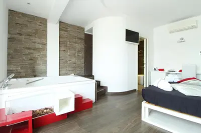a bedroom with a bathroom with a tub and a bed at Caos Calmo in Rome