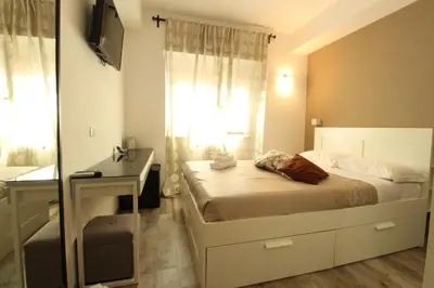 a bedroom with a bed and a desk and a window at Caos Calmo in Rome