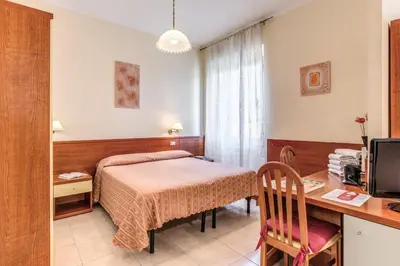 a bedroom with a bed and a desk with a computer at Hotel Katty in Rome